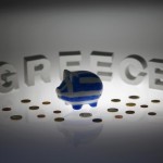 Piggybank painted in colours of Greek flag stands in front of letters spelling word 'GREECE' in this picture illustration taken in Berlin