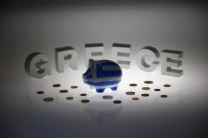 Piggybank painted in colours of Greek flag stands in front of letters spelling word 'GREECE' in this picture illustration taken in Berlin